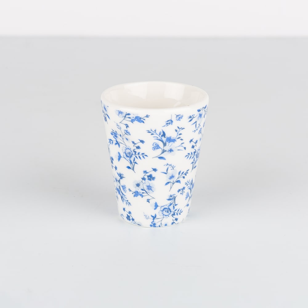 Taza de caf&eacute; de porcelana blanca con flores azules